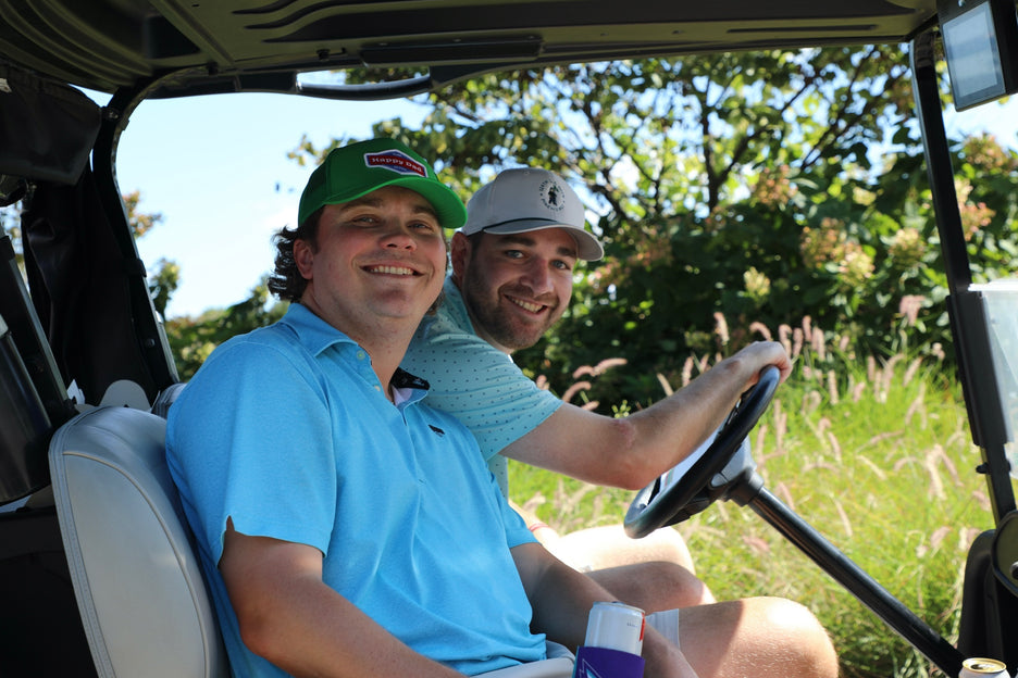 Two men in a golf cart on a golf course