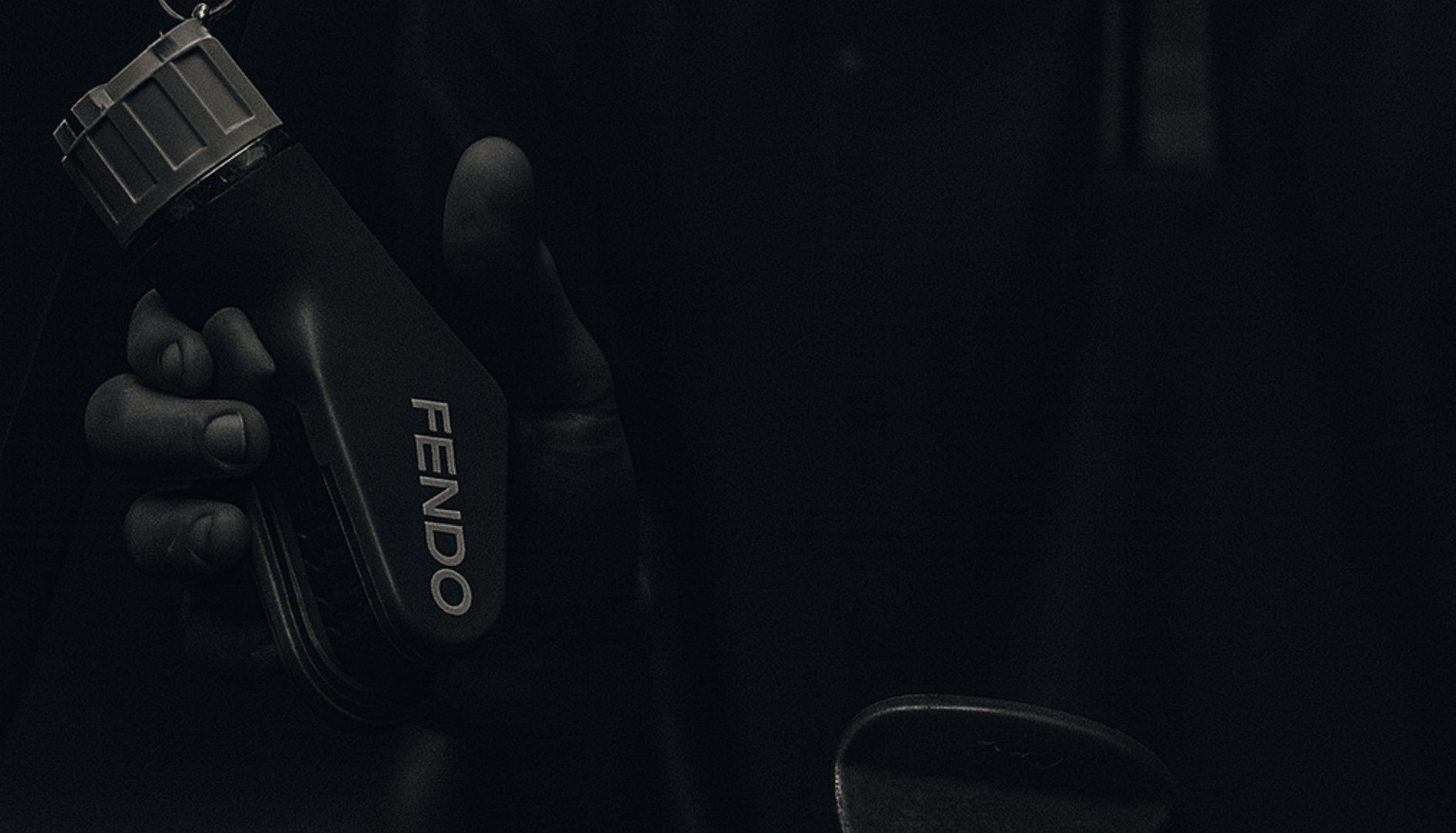 Person holding a black Fendo in a dark setting