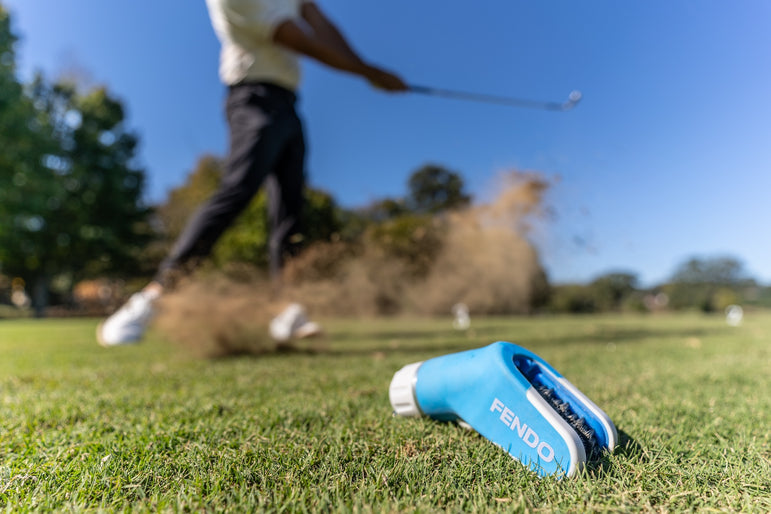 Golf ball mid-spin with clean grooves thanks to Fendo—highlighting performance and control.