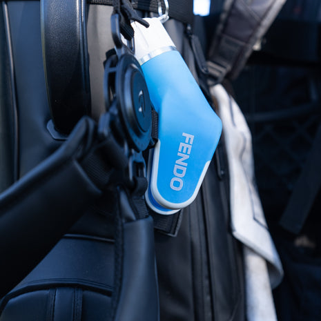 Fendo Club Cleaner clipped to a golf bag, ready for use on the course.
